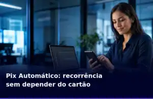 Empresaria-autoriza-uma-cobranca-recorrente-por-Pix-Automatico-no-celular-ao-lado-de-notebook-com-sistema-de-gestao.